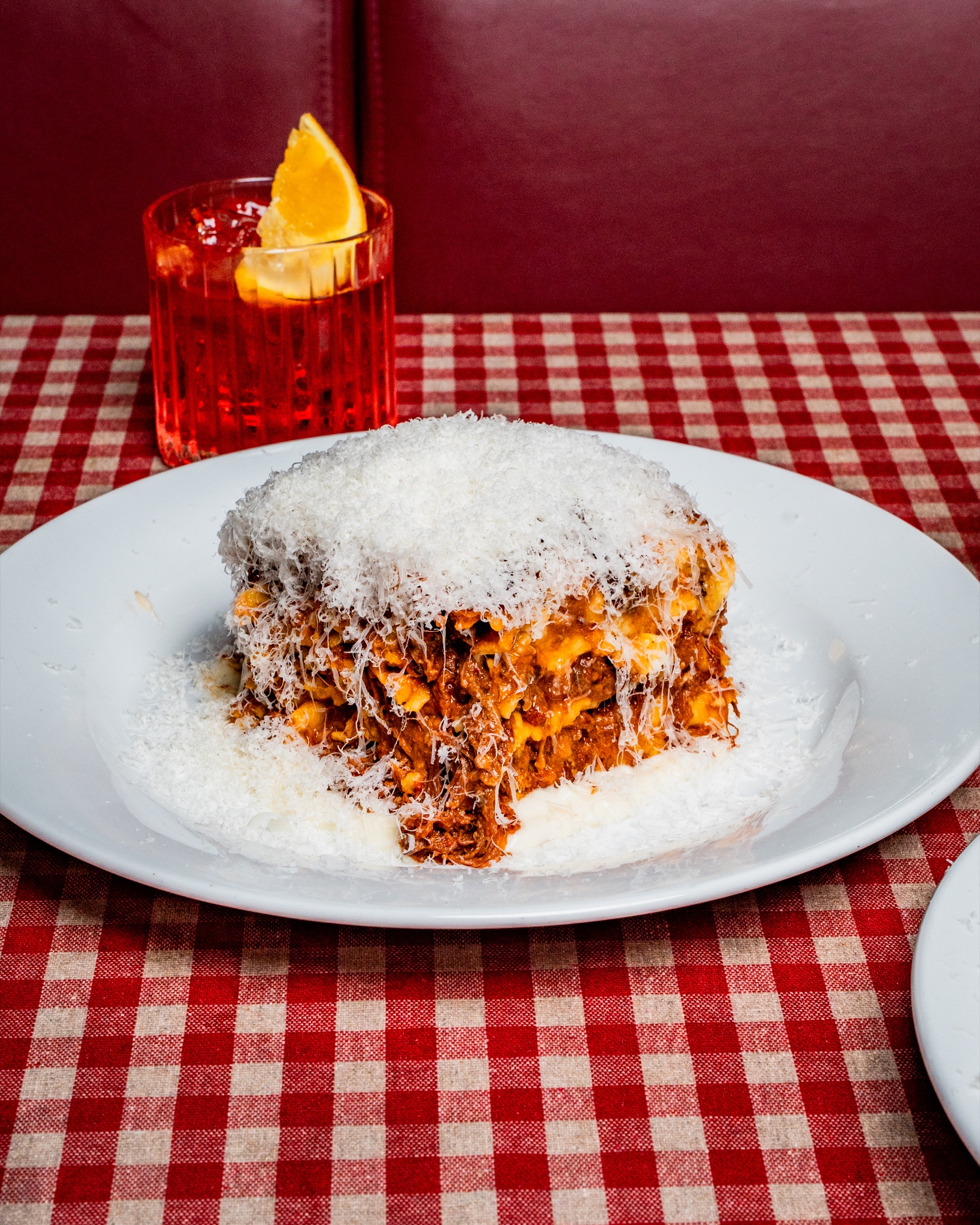 A serving of Senza Fondo beef lasagna with red wine